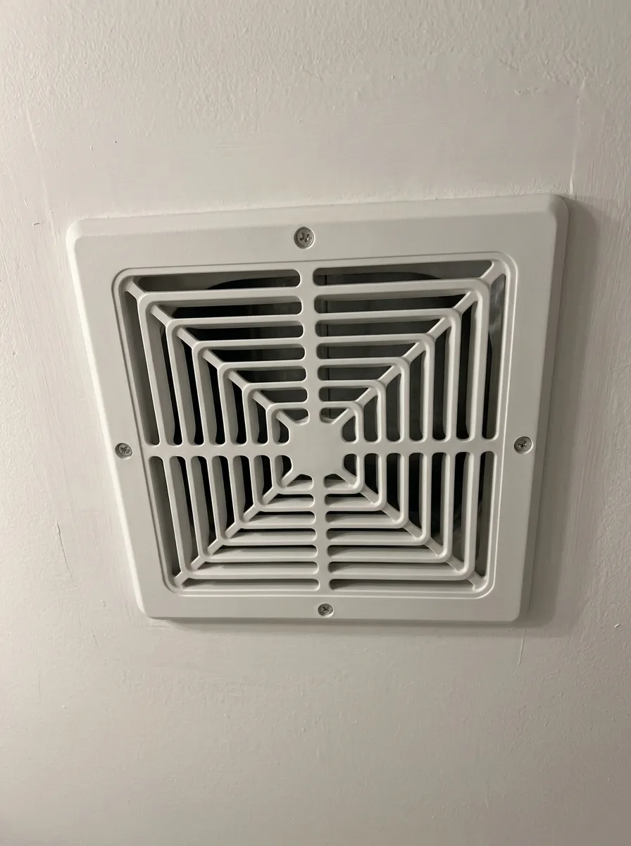 Bathroom exhaust grille, dust caked on the cover beside the cleared grille after cleaning