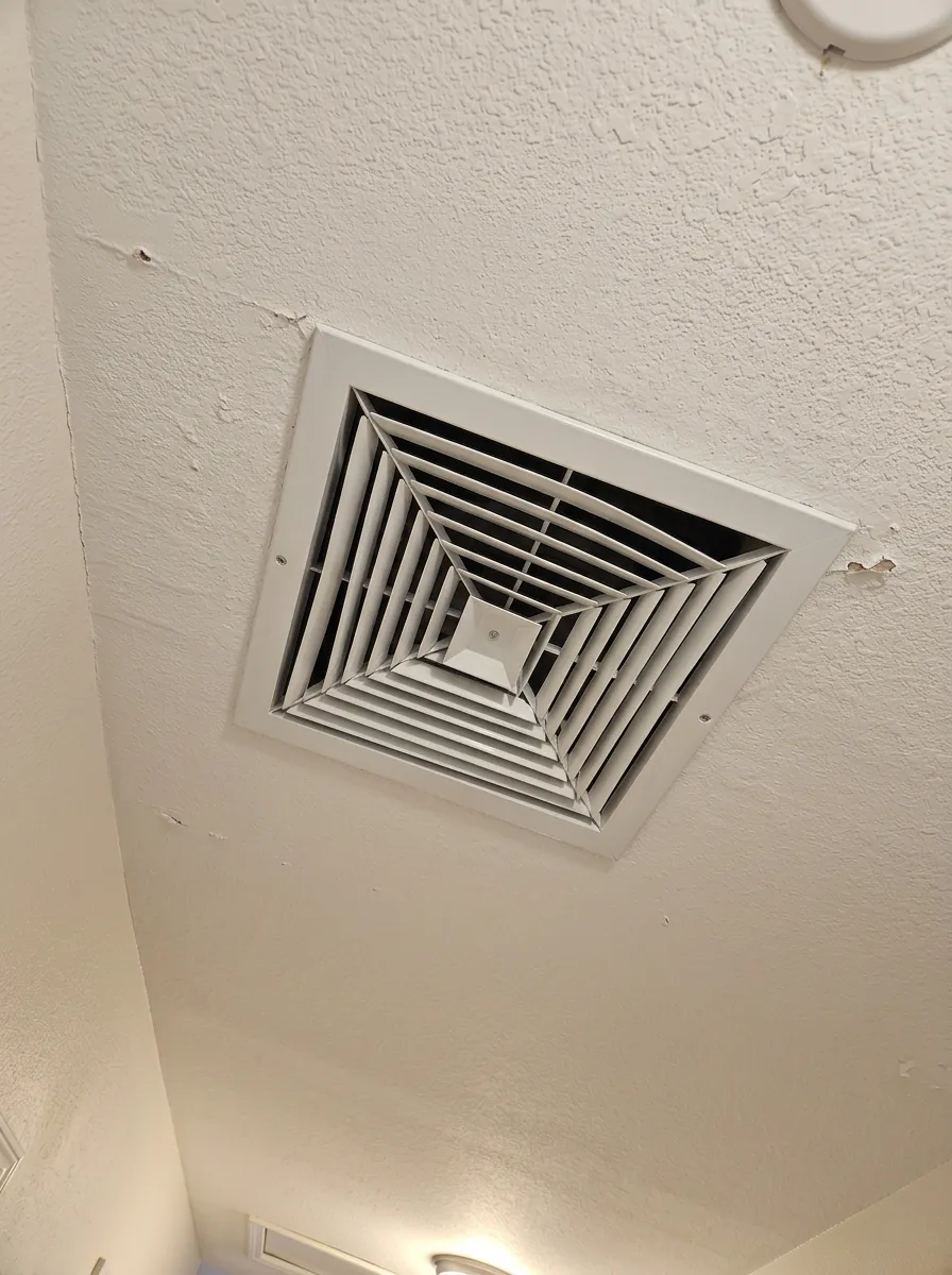 Ceiling supply diffuser, a dust ring beside the cleared grille after cleaning