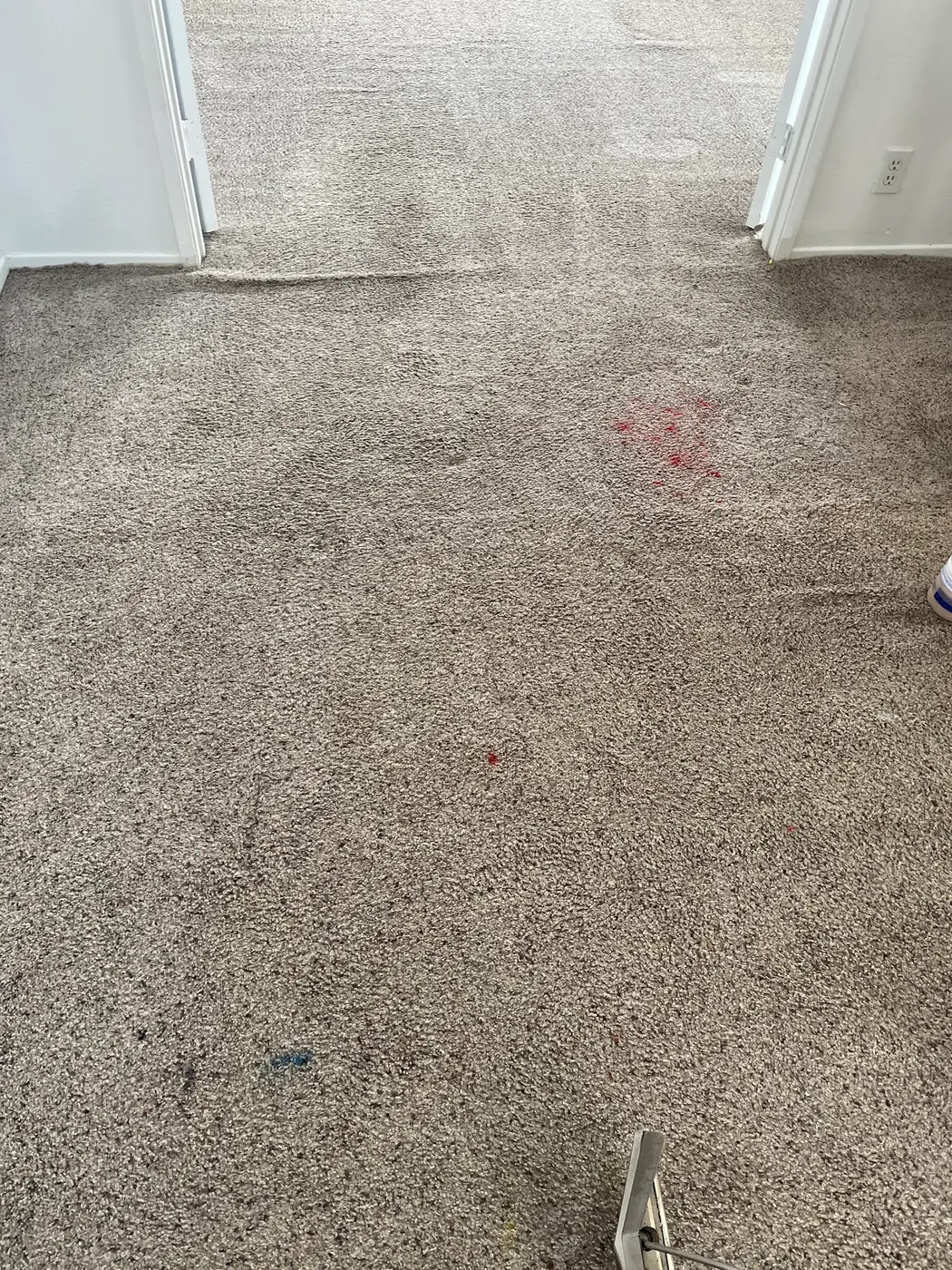 Carpet with a red spot beside the cleaned carpet before cleaning