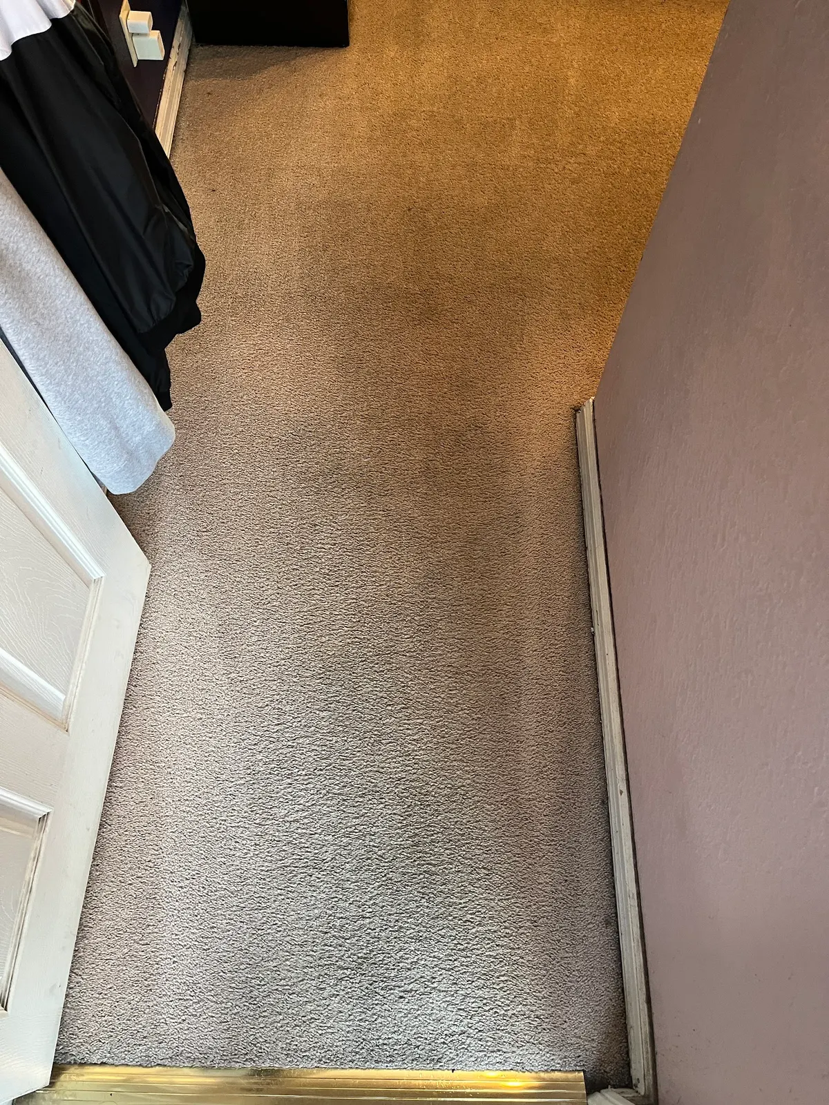 Bedroom doorway carpet, a blackened walking lane beside the cleaned carpet after cleaning