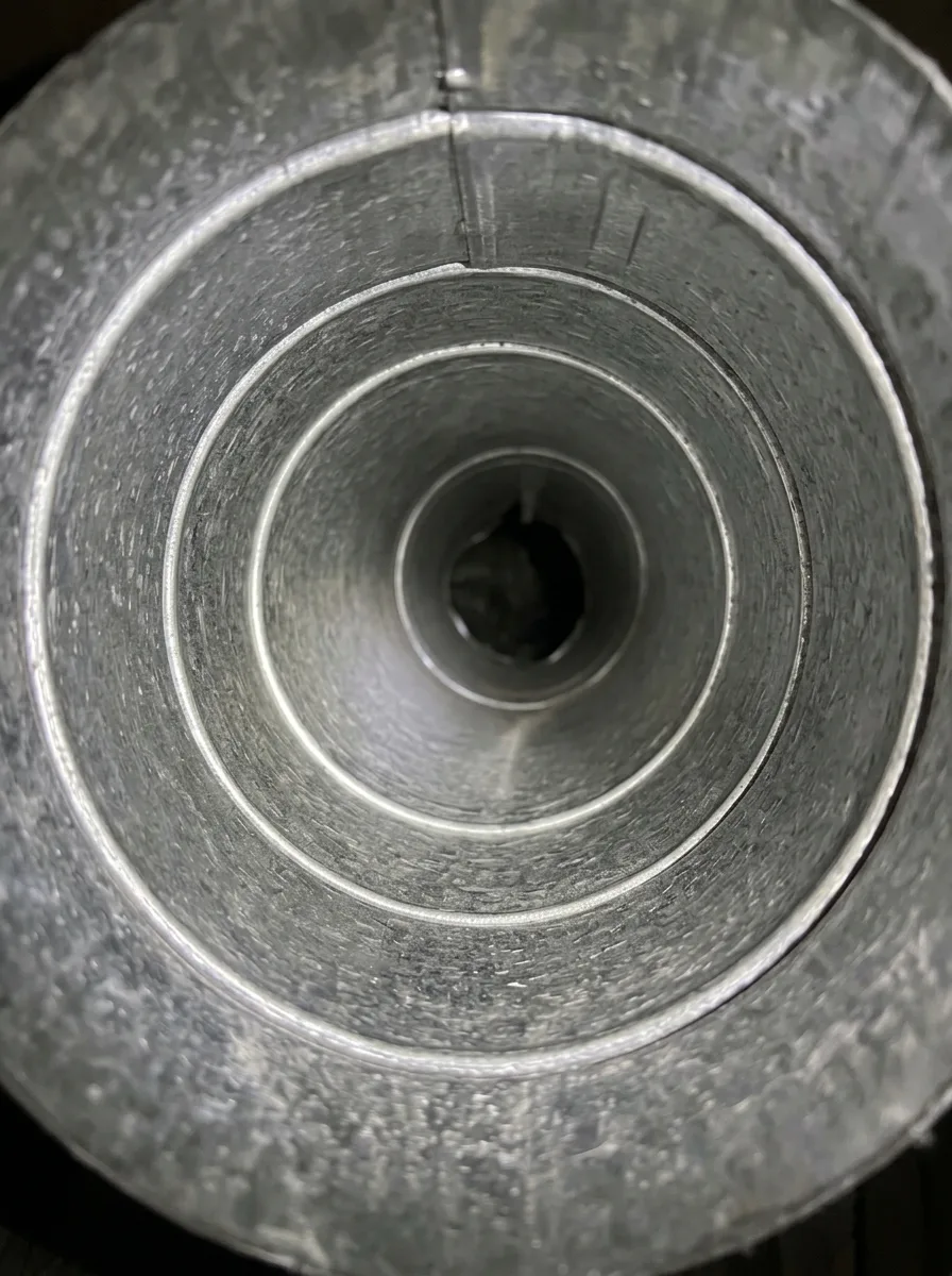 Dryer duct, lint packed inside beside the cleared metal after cleaning