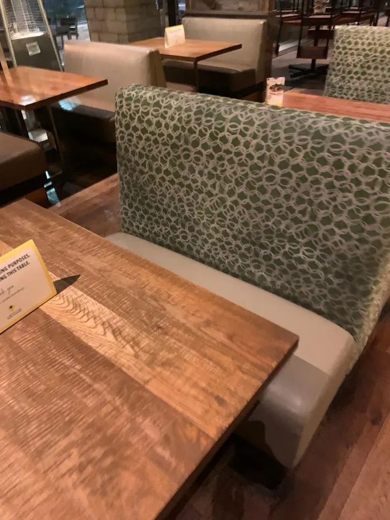 Restaurant booth seat, soiled fabric beside the cleaned seat before cleaning