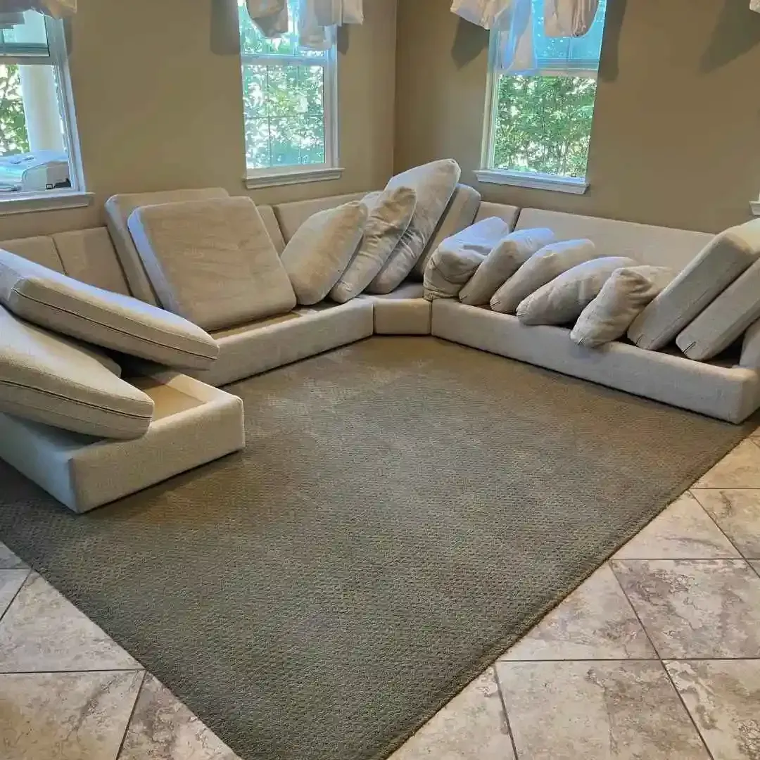 A sectional sofa with cushions removed, placed on a carpeted floor.
