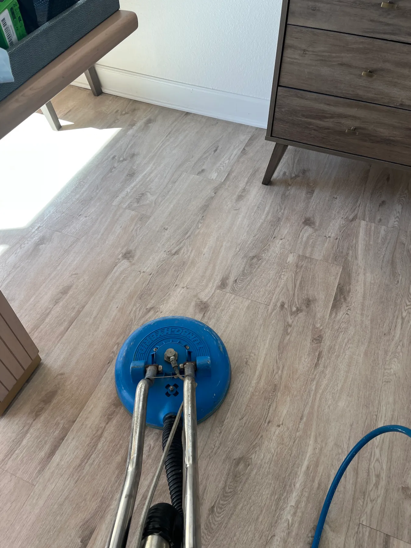Rotary floor machine on a light wood-look floor