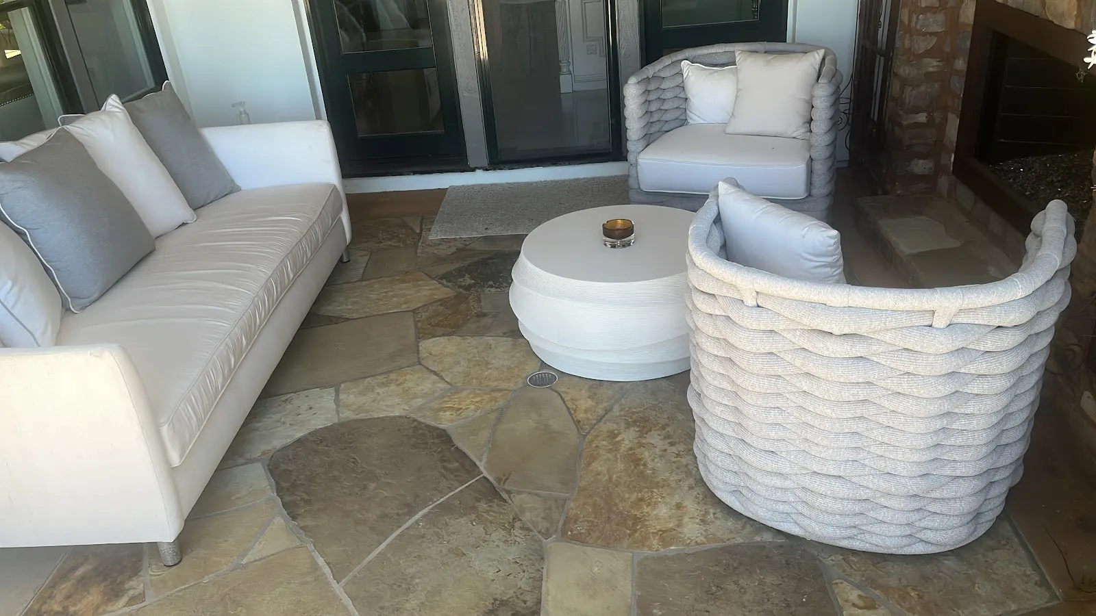 White outdoor sofa and chairs on a stone patio