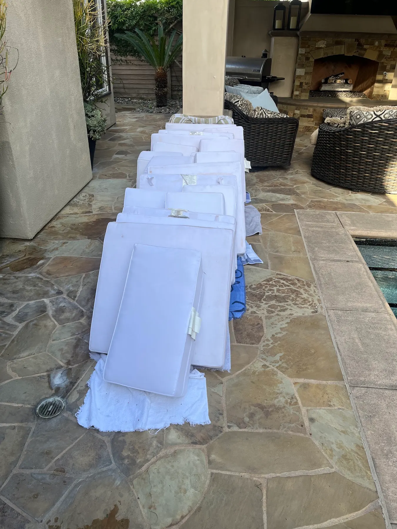 White outdoor cushions laid out beside a pool