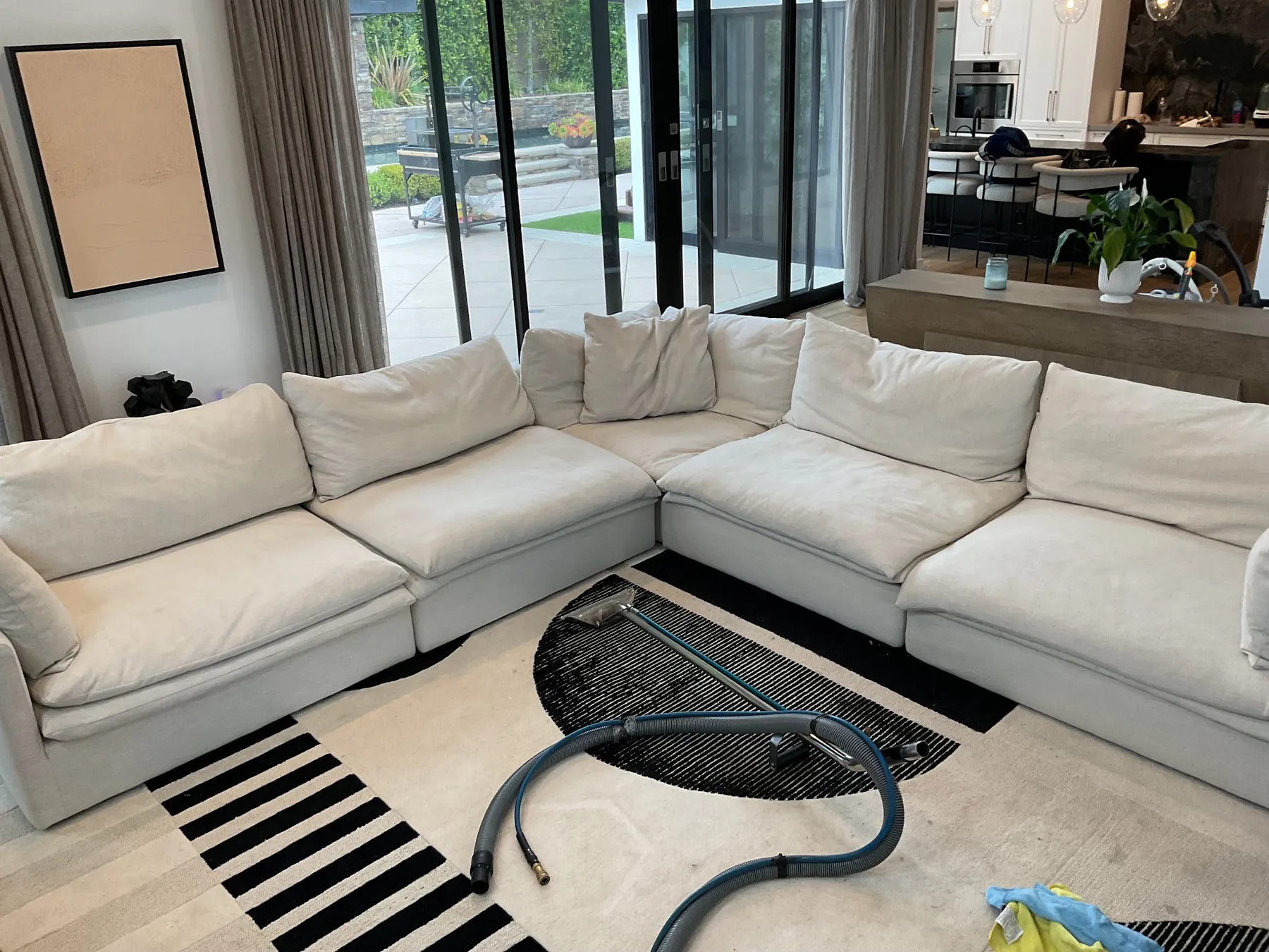 White sectional with a cleaning hose on a geometric rug