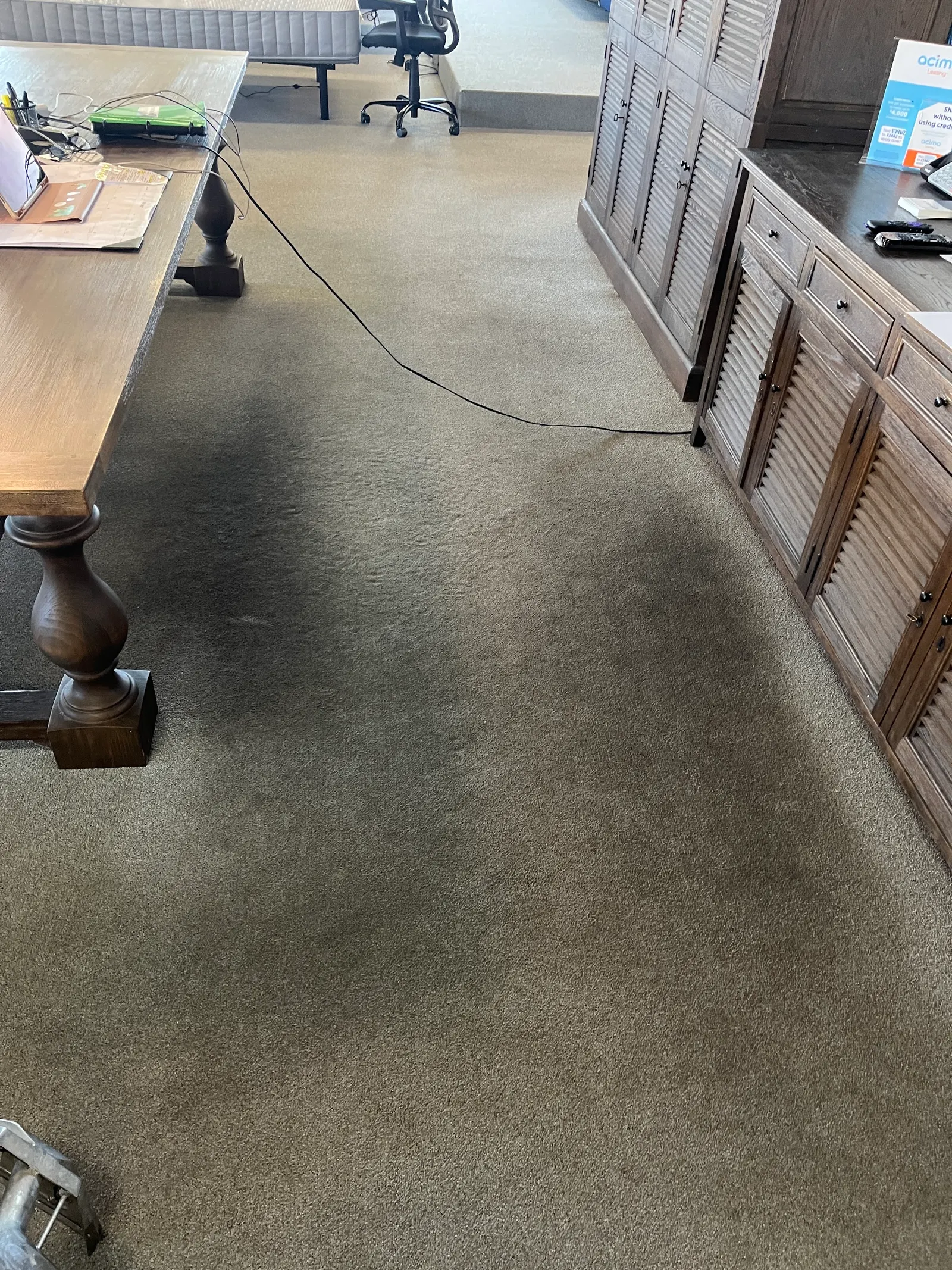 Dark soil on commercial carpet beside a display table