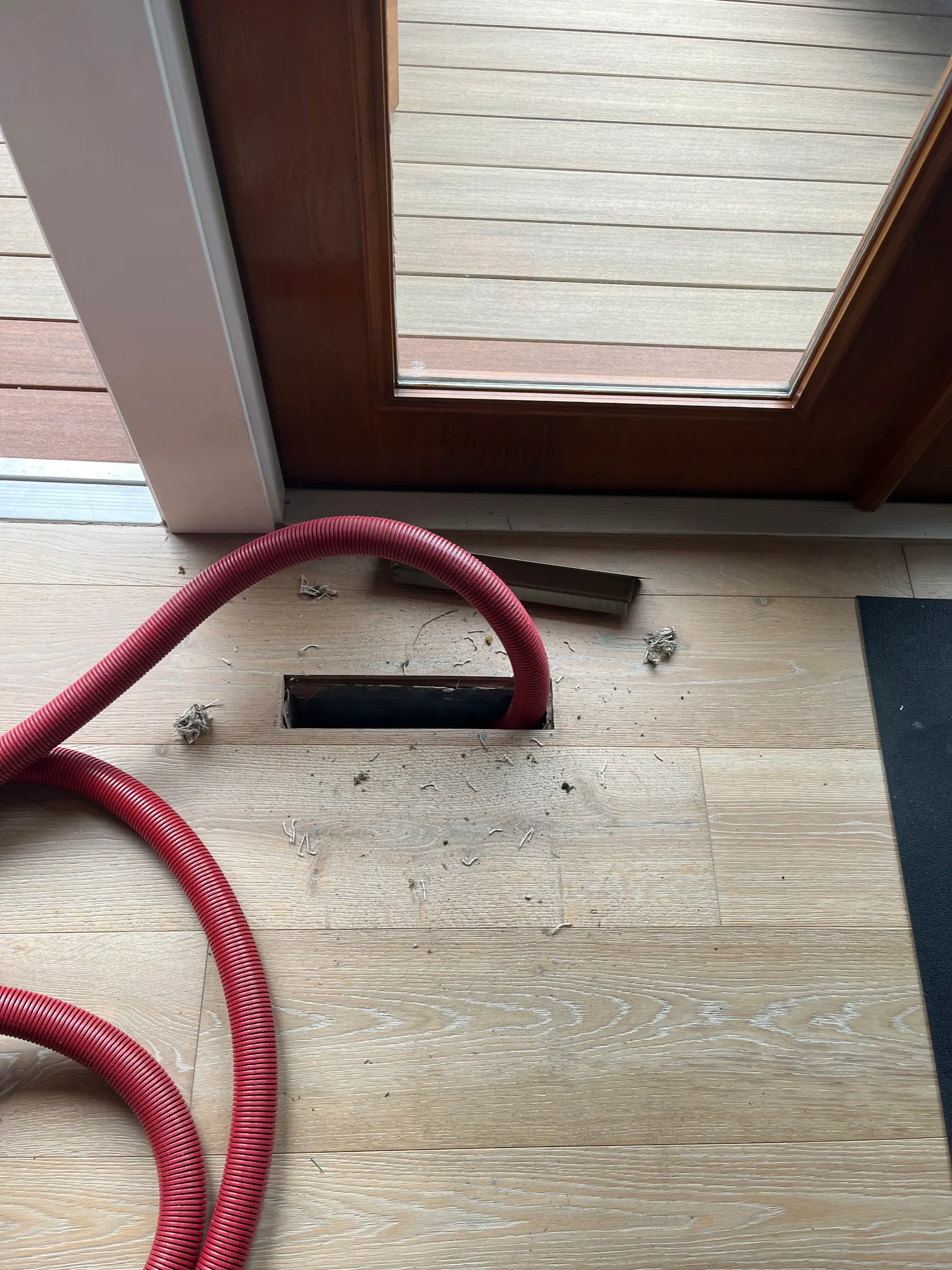 Red duct hose in a floor vent