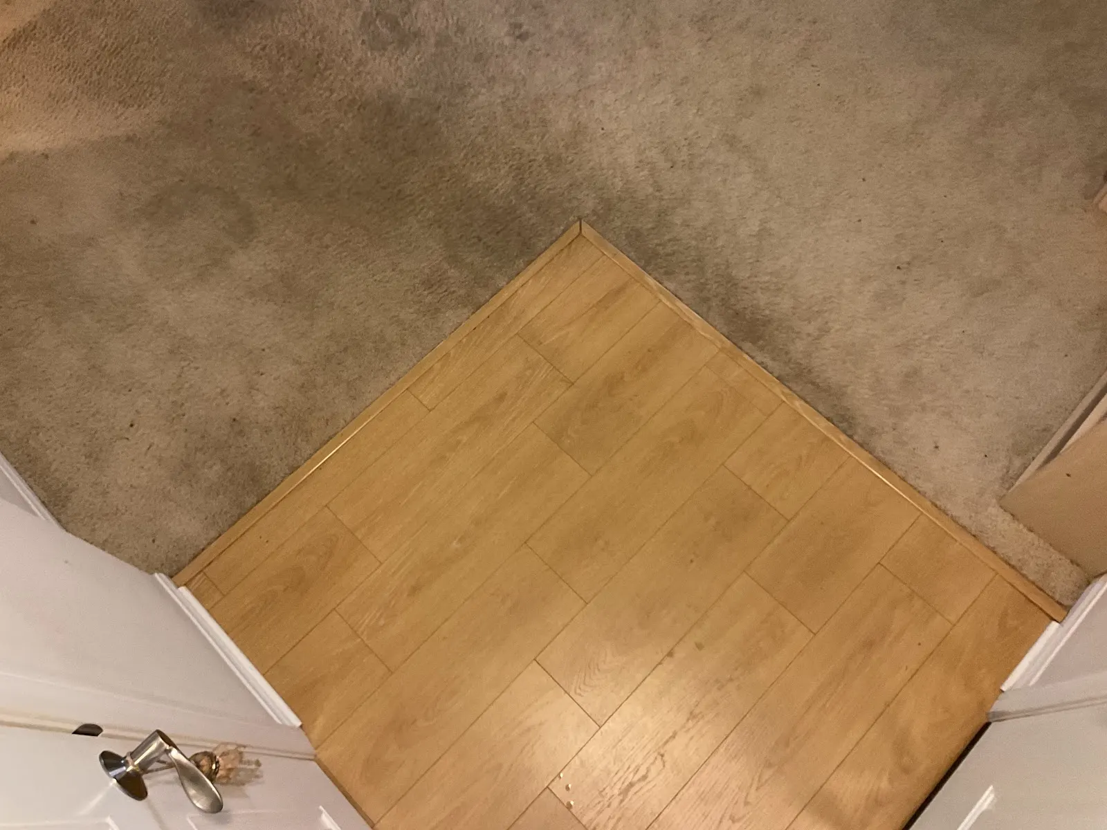 Laminate landing meeting carpet at a hallway corner