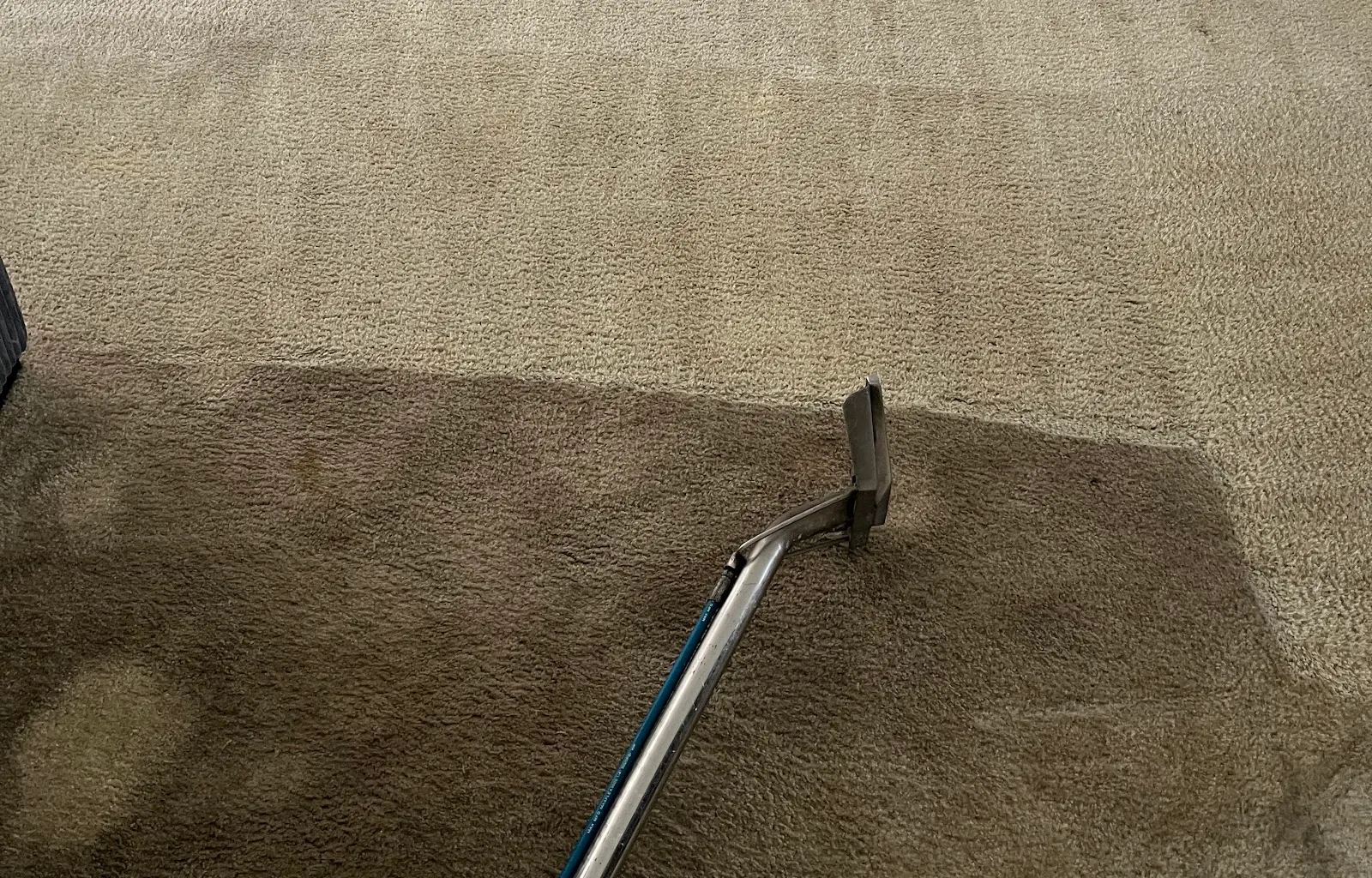 Truck-mounted cleaning wand crossing a soiled living room carpet on an Anaheim job