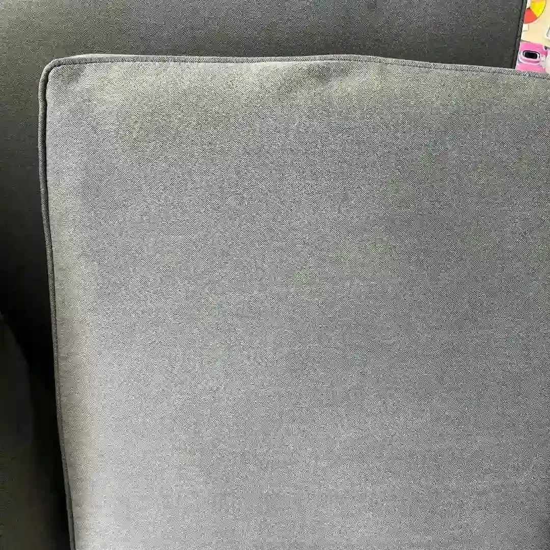 Close-up of a gray upholstered couch cushion.
