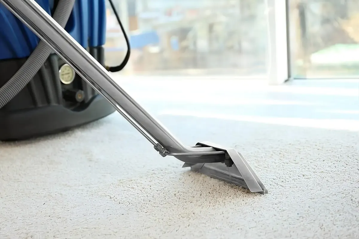 Close-up of a carpet cleaning machine head on a white carpet.