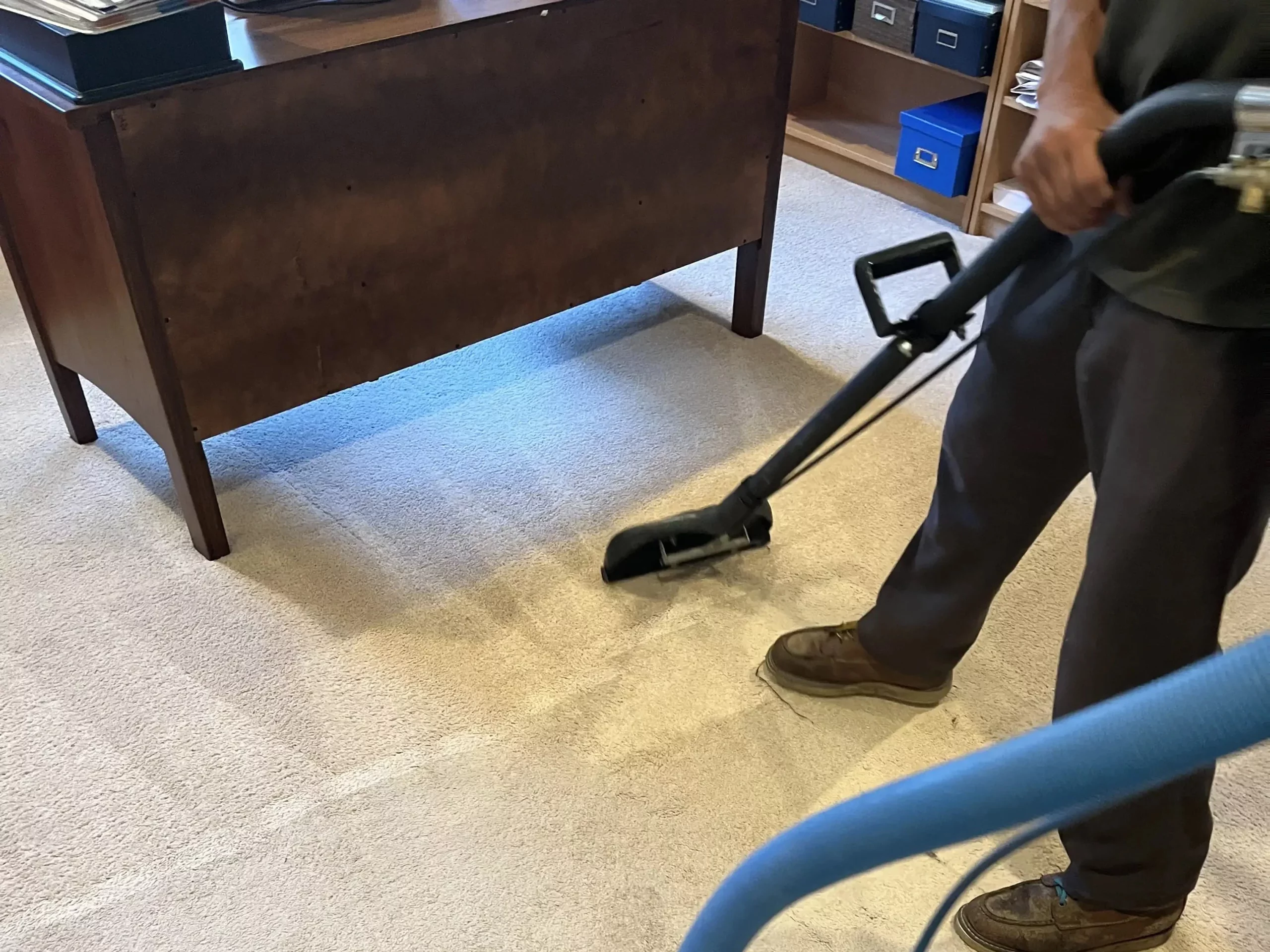 a person vacuuming carpet in a room