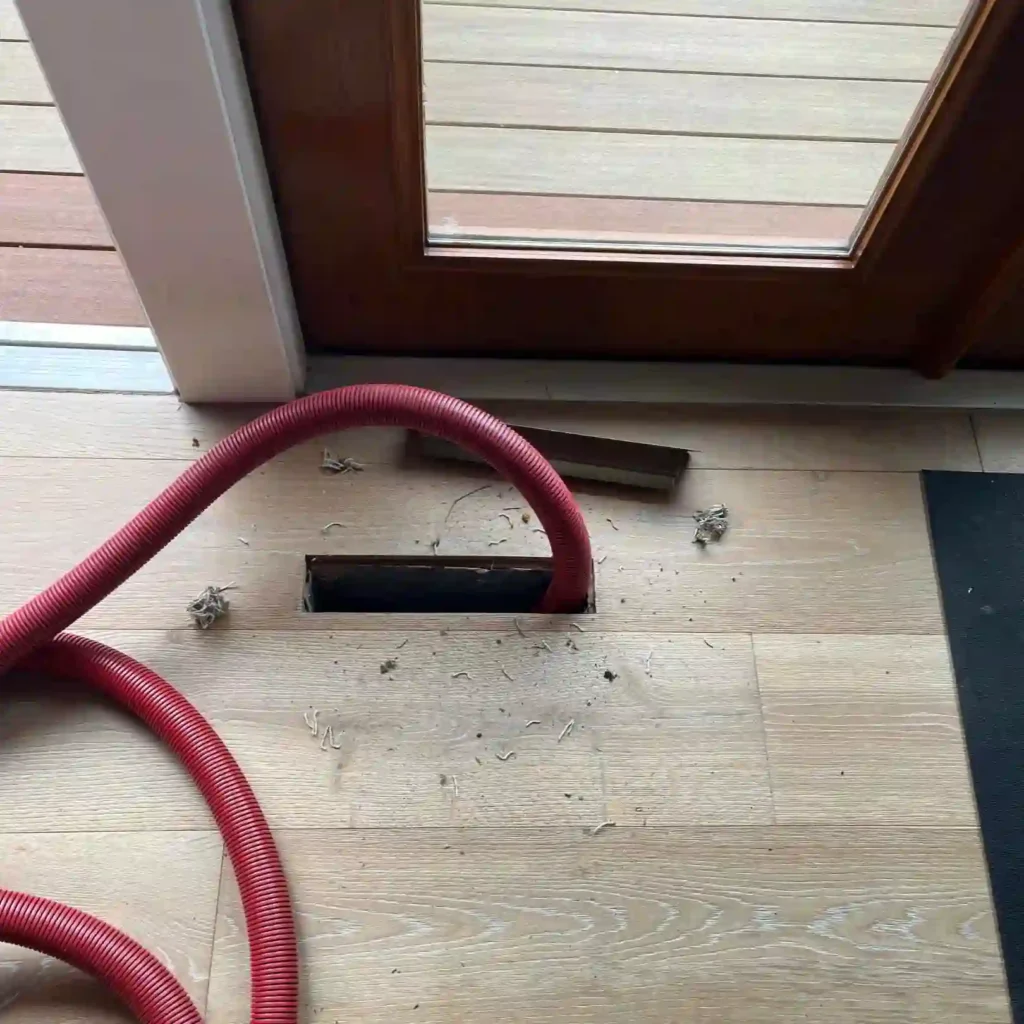 technician cleaning HVAC air ducts with professional vacuum equipment.