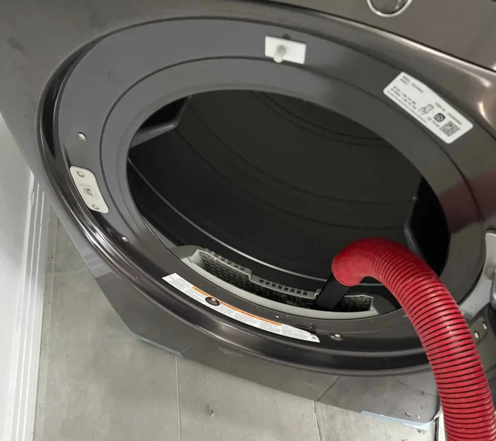 Technician cleaning clogged dryer vent system in Tustin